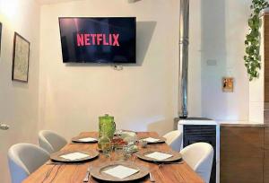 a wooden table with chairs and a television on a wall at Dimora Antonella - Ostuni 4 seasons - Splendid Villa Depandance with Private Swimming Pool in Ostuni