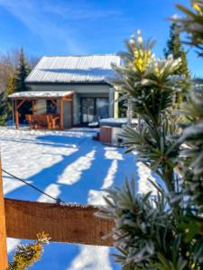 a house in the snow with a fence at Domek Na Miodowej in Sulistrowiczki