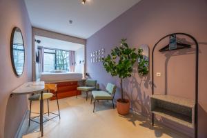 a bedroom with a bed and a table and chairs at hotel emma next in Rotterdam