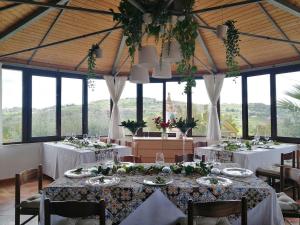 a dining room with white tables and chairs and windows at B&B Eyexei Domus in Agrigento +80 photos