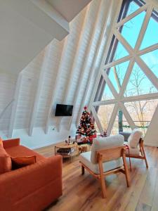 a living room with a christmas tree and a large window at PiatrA Frame in Ştefeşti