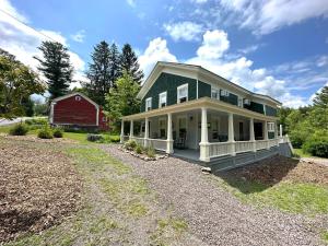 a large house with a red barn in the background at Mill Pond Inn in Jefferson