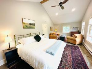 a bedroom with a large white bed with a ceiling fan at Mill Pond Inn in Jefferson