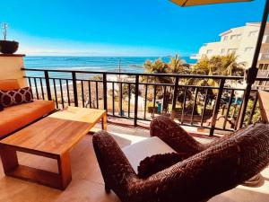 a balcony with two chairs and a table and the ocean at Pacific Ocean View Punta de Mita in Punta Mita