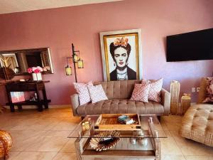 a living room with a couch and a painting of a woman at Pacific Ocean View Punta de Mita in Punta Mita