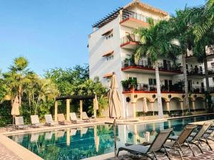 a hotel swimming pool with chairs and a building at Pacific Ocean View Punta de Mita in Punta Mita