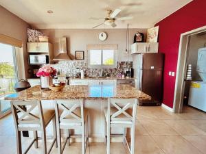 a kitchen with a large kitchen island with white stools at Pacific Ocean View Punta de Mita in Punta Mita +2 photos