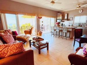 a living room with couches and a table and a kitchen at Pacific Ocean View Punta de Mita in Punta Mita