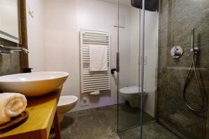 a bathroom with a sink and a glass shower at B&B Luggla - sauna in camera in Predoi +32 photos
