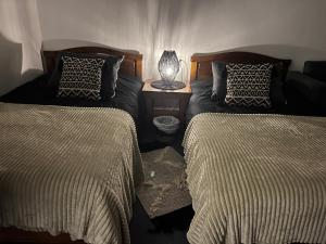 a bedroom with two beds and a table with a lamp at Tabarja Chalet Studio Sea & Mountain View in An Nā‘ūrah