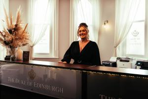 a woman sitting at a desk at the duke of durham at The Duke of Edinburgh Hotel & Bar in Barrow in Furness