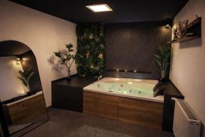 a large bathroom with a tub with plants in it at Wellnesshaus - Whirlpool - Sauna - Relax in Herten
