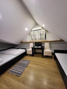 a attic room with two beds and a table and chairs at Kryształowa poddasze in Józefów