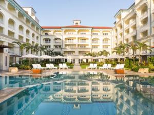 a hotel with a pool in front of a building at Eau Resort & Spa in South Palm Beach