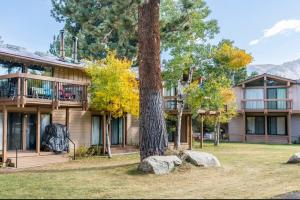 a building with a tree and rocks in front of it at Villa De Los Pinos 15 in Mammoth Lakes