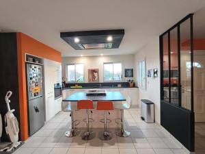 a kitchen with a blue counter and two bar stools at La Parenthèse colorée - spacieux - 12mn du Parc in Châteaumur