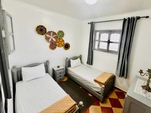 a room with two beds and a clock on the wall at Apartment with 2 bedrooms in Essaouira