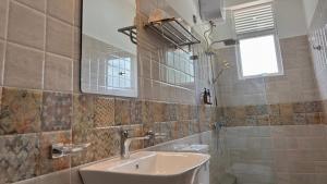 a bathroom with a sink and a toilet and a mirror at EK Breeze Kalutara in Kalutara