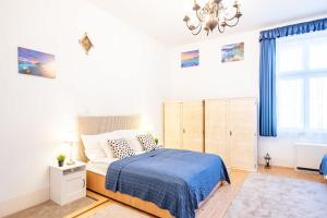 a bedroom with a bed and a chandelier at Jacuzzi - Riverside - Garden in Kismaros