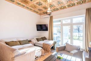 a living room with a coffered ceiling and a couch at Jacuzzi - Riverside - Garden in Kismaros