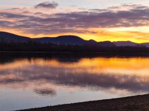 a sunset over a lake with mountains in the background at Jacuzzi - Riverside - Garden in Kismaros +44 photos