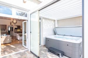 a bath tub in a room with a large window at Jacuzzi - Riverside - Garden in Kismaros