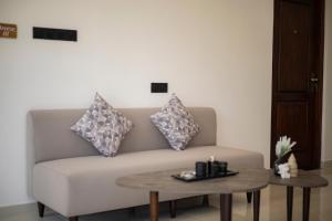 a living room with a couch with pillows and a table at EK Breeze Kalutara in Kalutara +86 photos