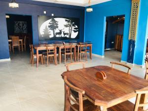 a dining room with wooden tables and chairs at Oasis Wings Hotel in Mannar