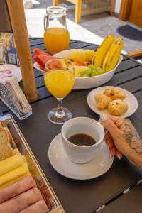 a table with a tray of food and a cup of coffee at Pousada Praia do Carioca Búzios in Búzios