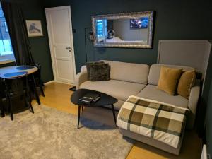 a living room with a couch and a table and a mirror at E&E Apartment Junior in Svolvær
