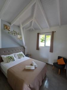 a bedroom with a large white bed with a window at LES MULTIPLIANTS in Le Moule