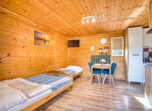 a room with two beds and a table in it at Domki parterowe ANITA in Zawóz