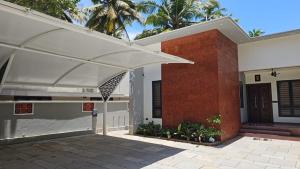 a house with a large white umbrella in front of it at HRISHI Guest Suites 3Bhk in Trivandrum