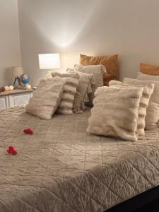a large bed with white pillows and red flowers on it at L abricosy in Drancy