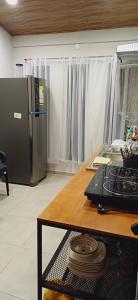 a kitchen with a table and a refrigerator in a room at Casa M&T in Encarnación