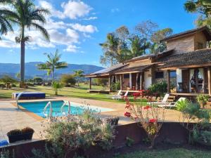 a house with a swimming pool and a resort at Pousada Contempla Joanópolis in Joanópolis