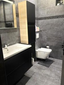 a bathroom with a white sink and a toilet at L abricosy in Drancy