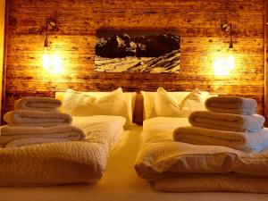 a room with towels stacked on top of a bed at B&B Luggla - sauna in camera in Predoi