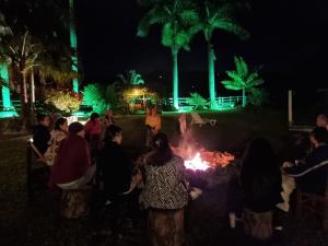 a group of people standing around a fire at night at Pousada Contempla Joanópolis in Joanópolis +238 photos