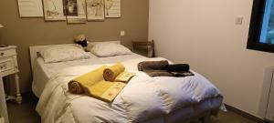 a bed with towels and a stuffed animal sitting on it at Le Saint Jacques in Nans-les-Pins