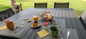 a table with food and drinks and a basket of bread at Le Saint Jacques in Nans-les-Pins