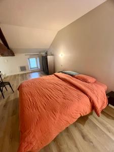 a bedroom with a bed with an orange blanket at Duplex spacieux-2chambres-ideal vehicule electrique in Melle +1 photo