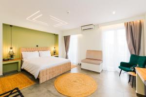 a bedroom with a bed and a chair and a table at Aether Athens Urban Hotel in Athens