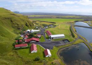 an aerial view of a farm on a hill next to water at Hotel Katla by Keahotels in Vík