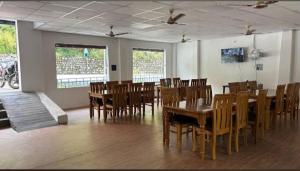 a dining room with wooden tables and chairs at Hotel prayagraj in Barkot