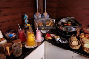 a kitchen with a buffet of food and drinks at Pousada e Chalé Lote 22 in Ilha do Mel
