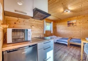 a kitchen in a log cabin with a bed at Domki parterowe ANITA in Zawóz