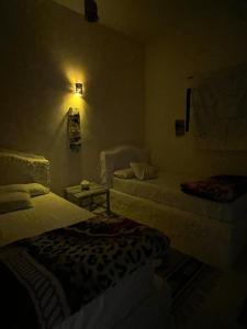 a dark room with two beds and a lamp at Soliman House Siwa in Siwa +20 photos