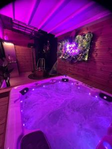 a large purple tub in a room with purple lights at Sxcape ROOM in Aigues-Mortes