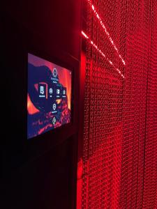 a television with red lights on a wall at Sxcape ROOM in Aigues-Mortes